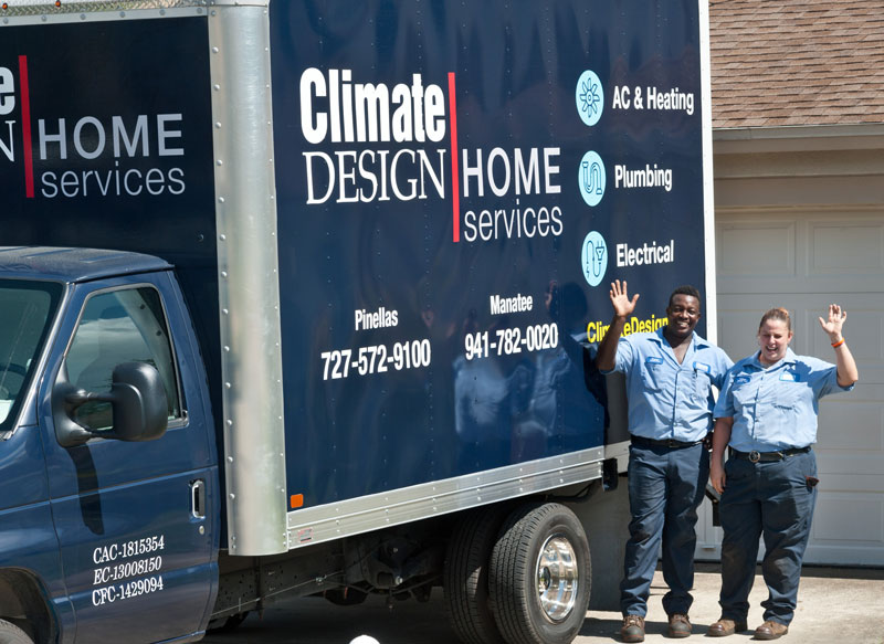 Two Climate Design technicians standing beside the Climate Design truck waving.